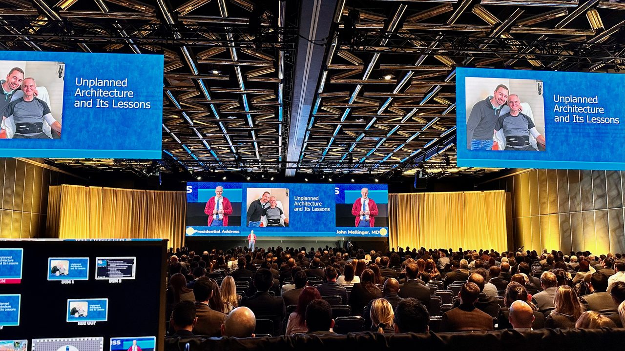 A/V production desk view of large medical conference with IMAG screens